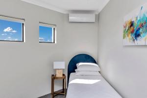 a bedroom with two beds and two windows at Oceanfront Retreat With Stunning Marina Views in Mandurah