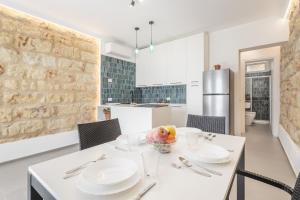 a kitchen and dining room with a white table and chairs at La Casetta sul Mare in Palermo +13 photos