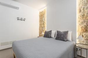 a white bedroom with a bed in a room at La Casetta sul Mare in Palermo