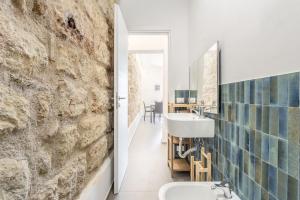 a bathroom with two sinks and a stone wall at La Casetta sul Mare in Palermo