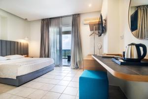 a hotel room with a bed and a desk at Aegean Sun Hotel in Skala Rachoniou