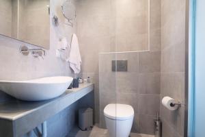 a bathroom with a white sink and a toilet at Aegean Sun Hotel in Skala Rachoniou