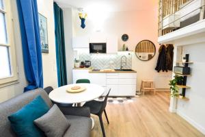 a living room with a table and a kitchen at Hyper-Centre Studio Lekain UnSejourANantes in Nantes
