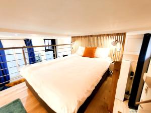 a large white bed in a room with windows at Hyper-Centre Studio Lekain UnSejourANantes in Nantes