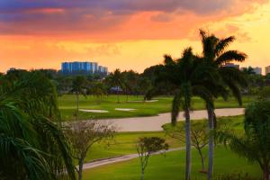 a sunset over a golf course with palm trees at Sheraton Miami Airport Hotel and Executive Meeting Center in Miami