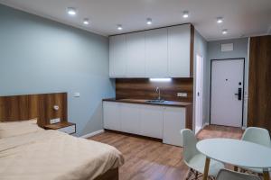 a bedroom with a bed and a table and a kitchen at Sunny Spot Batumi in Batumi +32 photos