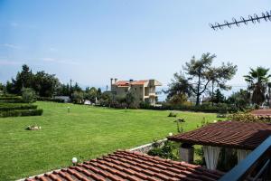 a view of a yard with a large lawn at Maisonette with sea and mountain view !!! in Kriopigi