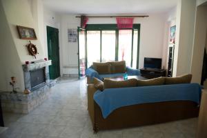 a living room with a couch and a fireplace at Maisonette with sea and mountain view !!! in Kriopigi