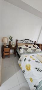 a bedroom with a bed and a table with a lamp at Homey822 in Davao City