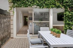 ein weißer Tisch und Stühle auf einer Terrasse in der Unterkunft Adelaide Oval Townhouse - Walk to the AFL & CBD in North Adelaide