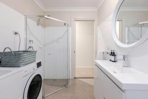 ein weißes Badezimmer mit einer Waschmaschine und einem Waschbecken in der Unterkunft Adelaide Oval Townhouse - Walk to the AFL & CBD in North Adelaide + 24 Fotos
