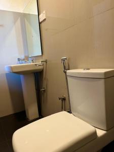 a bathroom with a white toilet and a sink at Kamatha Hotel & Restaurant in Ambalantota +70 photos