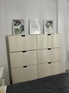 a white dresser with three photos on top of it at Acogedor al lado de el mar in Roquetas de Mar +10 photos