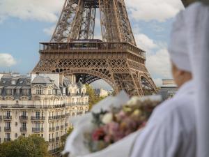 a person holding a bouquet of flowers in front of the eiffel tower at Pullman Paris Tour Eiffel in Paris