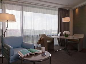 a living room with a chair and a table with books at Pullman Paris Tour Eiffel in Paris