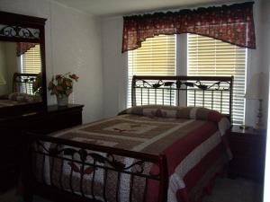 - une chambre avec un lit, un miroir et une fenêtre dans l'établissement Rainbow House, à Angel Fire