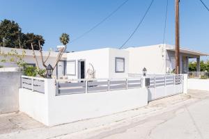 a white fence in front of a white house at K&Ε guest house in Ampavris