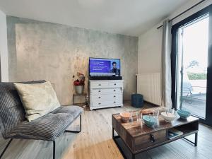 un soggiorno con un divano, un tavolo e una TV di La maison des vignes 3chambres jardin proche Reims a Jonchery-sur-Vesle