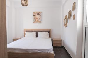 a bedroom with a bed with white sheets at K&Ε guest house in Ampavris