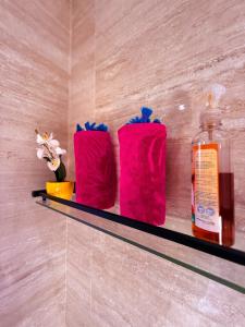 een plank met twee roze handdoeken en een fles erop bij Privilege house Opale in Marrakesh