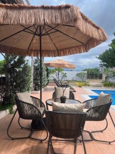 Un patio con sillas y una mesa con sombrilla. en Casa Lily a private villa, en San Fernando