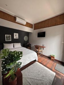 a bedroom with a bed and a table and a television at Sutji living in Sanur