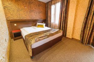 A bed or beds in a room at Eleganza Family Hotel - Free Parking