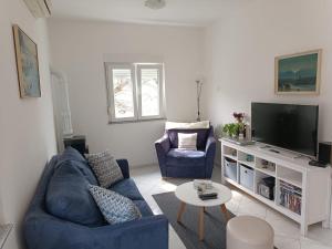 Una sala de estar con un sofá azul y un televisor en Sunny Family Apartment, en Gornji Karin