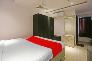 a bedroom with a white bed and a green cabinet at Super Hotel O Botcha Convection in Visakhapatnam