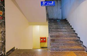a staircase in a building with a blue sign on it at Super Hotel O Botcha Convection in Visakhapatnam