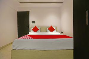 a bedroom with a large bed with red pillows at Super Hotel O Botcha Convection in Visakhapatnam