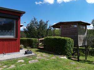 a gazebo next to a red building at Ferienhaus Mühlberg 4 in Braunschwende