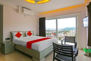 a bedroom with a bed and a large window at Super Hotel O Botcha Convection in Visakhapatnam
