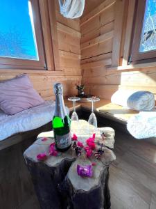 una habitación con una botella de vino y dos copas en un tronco en Privat Sauna Whirlpool Blockhaus- Balance Apartments by M&A, en Witzenhausen