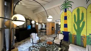 una sala de estar con un mural de cactus en la pared en Montalto Luxury House, en Siracusa