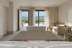 ein Schlafzimmer mit zwei Betten und ein Wohnzimmer in der Unterkunft Parilio, a Member of Design Hotels in Naoussa