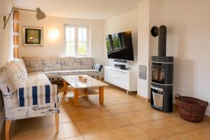 a living room with a couch and a stove at Strandnahes Reethaus Elefant Mit Außenwhirlpool in Gramkow