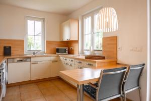 a kitchen with a wooden table and a table and chairs at Strandnahes Reethaus Elefant Mit Außenwhirlpool in Gramkow