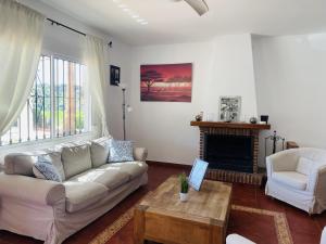 un salon avec un canapé et une cheminée dans l'établissement Cortijo Mira con piscina privada by At Home, à Río