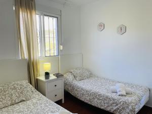 une chambre avec deux lits et une fenêtre dans l'établissement Cortijo Mira con piscina privada by At Home, à Río 49 autres photos