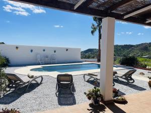 un patio avec des chaises et une piscine dans l'établissement Cortijo Mira con piscina privada by At Home, à Río