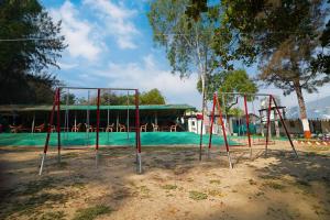 a group of swings in front of a playground at Bubbles of luxury Dublagadi Beach in Sindhia