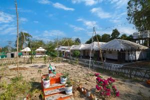 a garden with tents and potted plants and flowers at Bubbles of luxury Dublagadi Beach in Sindhia