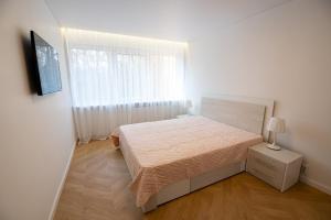 a small bedroom with a bed and a window at Klaipedas apartaments in Liepāja +9 photos