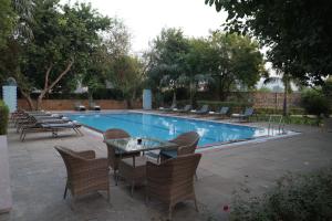 a patio with a table and chairs next to a pool at The Shergarh in Khilchipur
