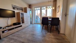 a dining room with a table and chairs and a television at Ferienwohnung Boje 6 in Schillig