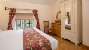 sypialnia z łóżkiem, komodą i oknem w obiekcie Crafty Cottage w mieście Chipping Campden