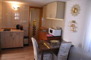a small kitchen with a table and a microwave at Šepić Accommodation in Žabljak