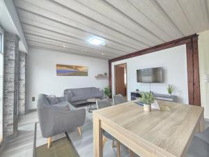 a living room with a wooden table and chairs at Ferienwohnung Kajüte 4 in Norden