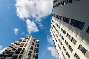 a tall building with the sky in the background at Kairos Apartments -Sky - darmowy parking podziemny, ścisłe centrum in Katowice